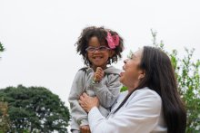 Woman plays with child or granddaughter who is smiling and happy